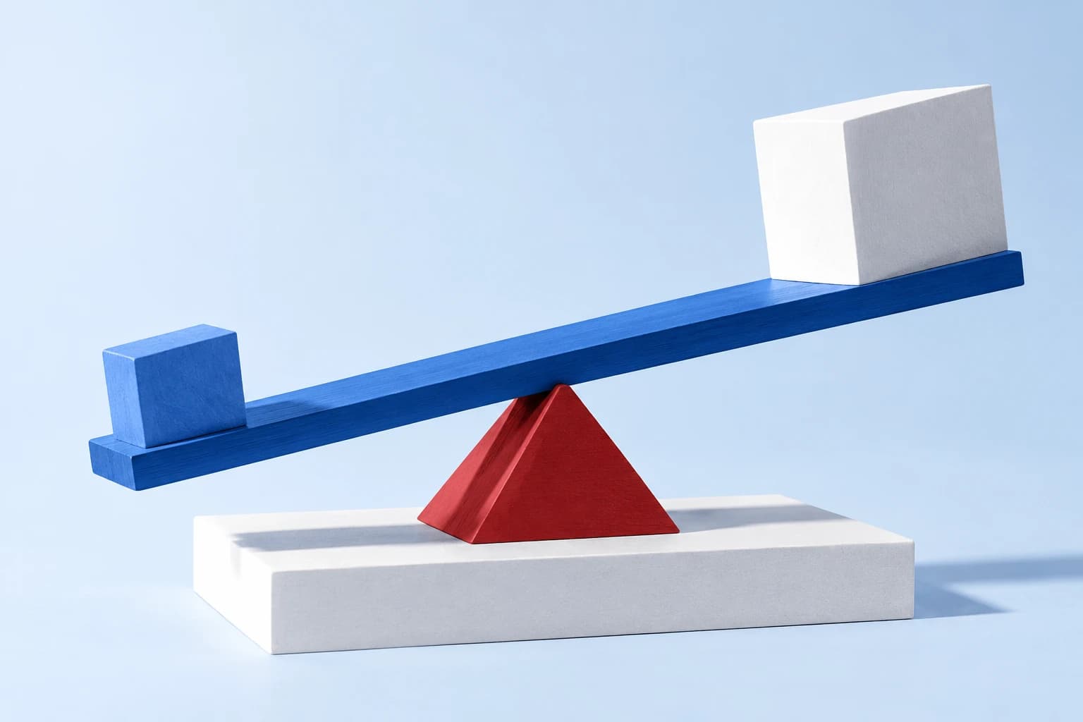 A blue lever on a red fulcrum lifts a white block from a broad, stable foundation.